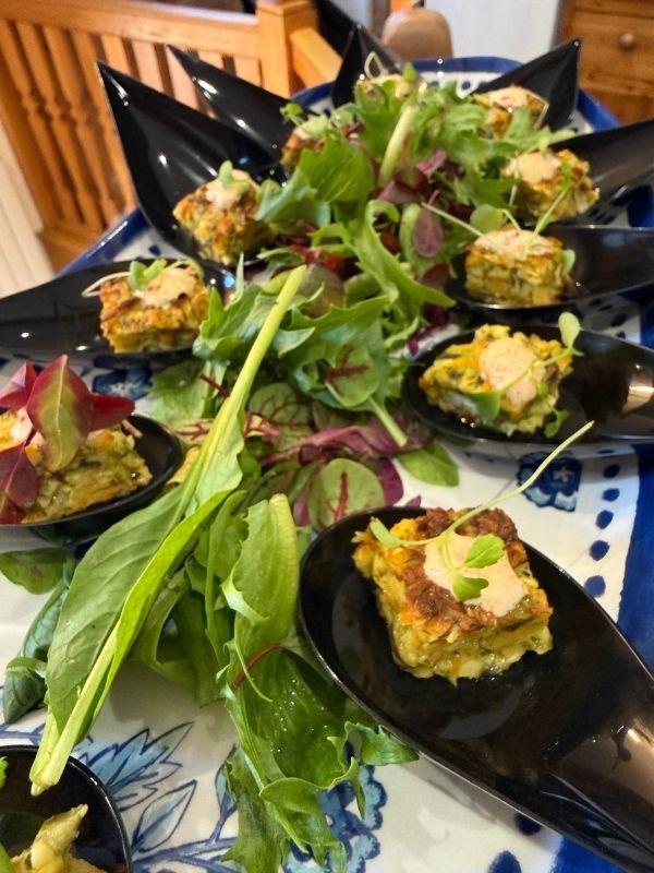Vegetable fritter canapés served on black spoons at a private chef event in Lincolnshire