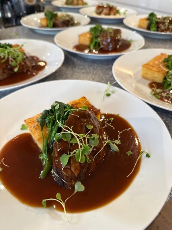 Braised beef shank with rich jus, plated as a main course for a private dining event in Lincolnshire